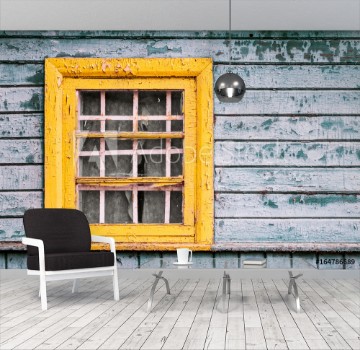 Picture of yellow window on green wooden wall of abandoned house